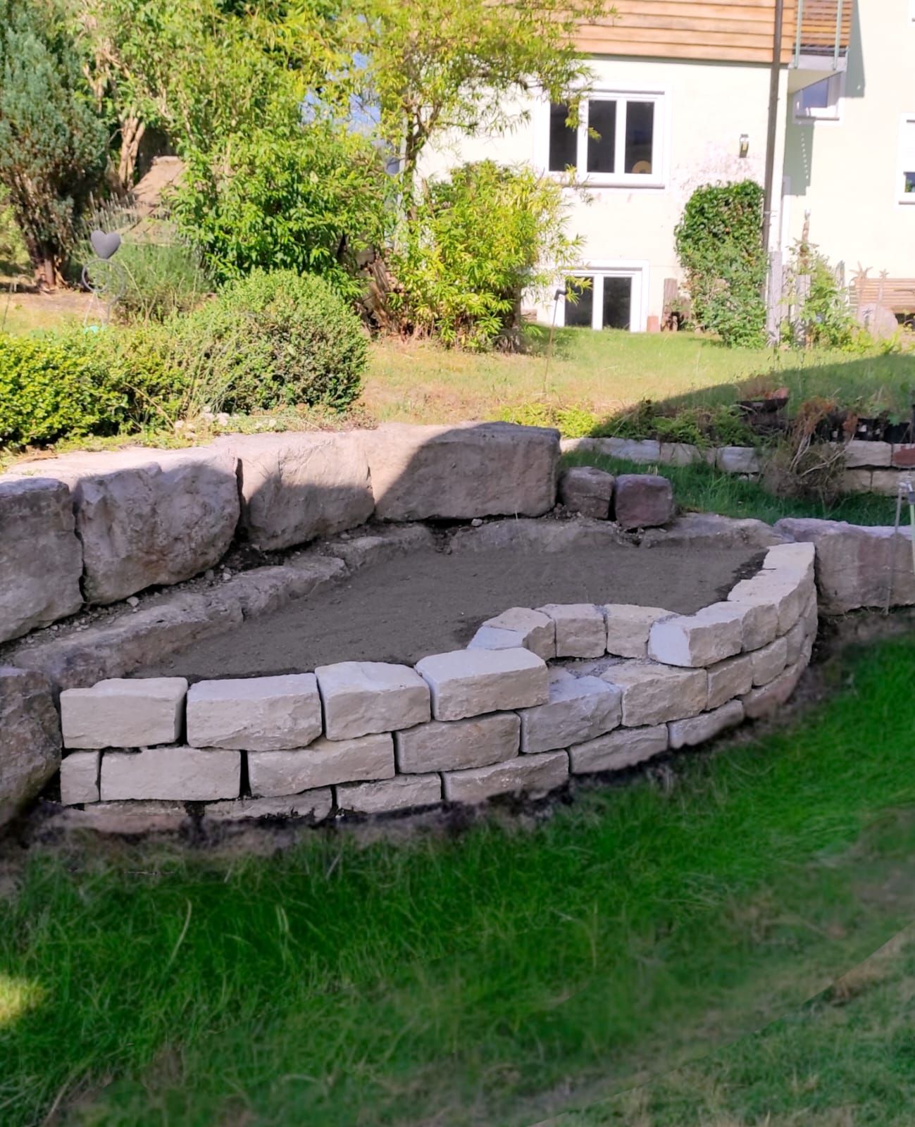 Hochbeet aus einer Naturstein-Trockenmauer im Hausgarten.